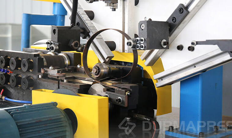 Seam locking and spiral forming process inside a spiral tubeformer.